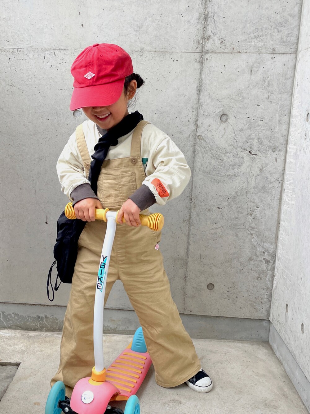 ベージュ系のTシャツ/カットソー、ブラック系のショルダーバッグ、ブラック系のスニーカーを着用したキッズの春コーディネートの2枚目の写真