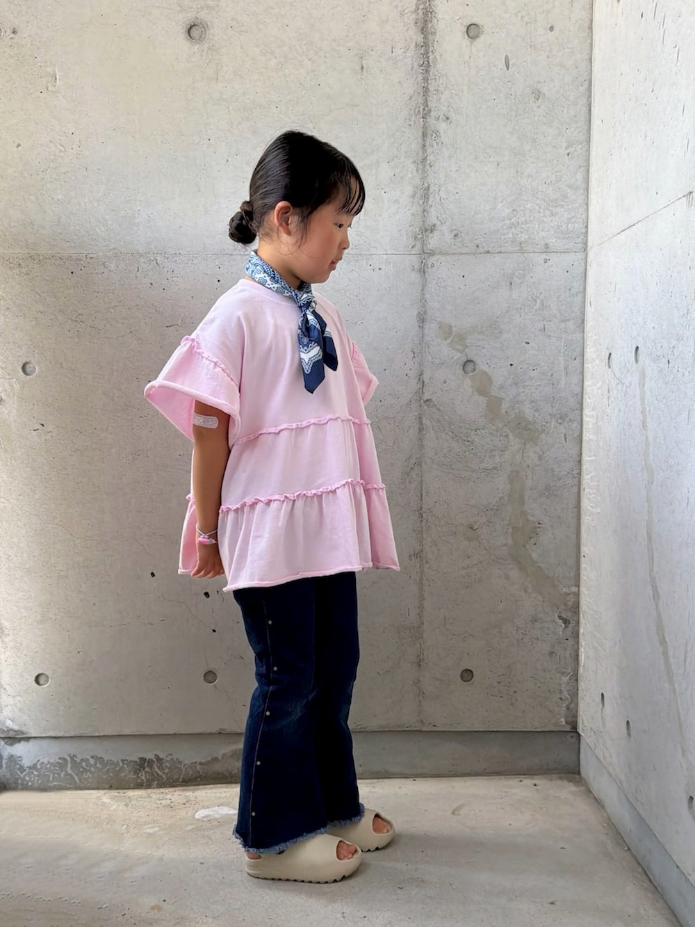 ピンク系のTシャツ/カットソー、ベージュ系のサンダル、ブルー系のデニムパンツを着用したキッズの夏コーディネートの5枚目の写真