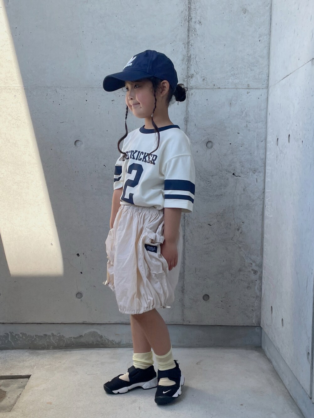 グリーン系のTシャツ/カットソー、ホワイト系のスカート、ブラック系のスニーカーを着用したキッズの夏コーディネートの4枚目の写真