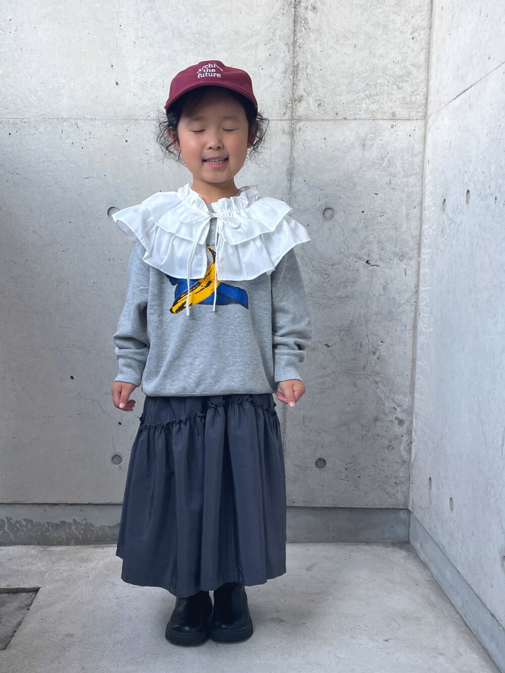 グレー系のワンピース、ブラック系のブーツ、グレー系のトップスを着用したキッズの秋コーディネートの3枚目の写真