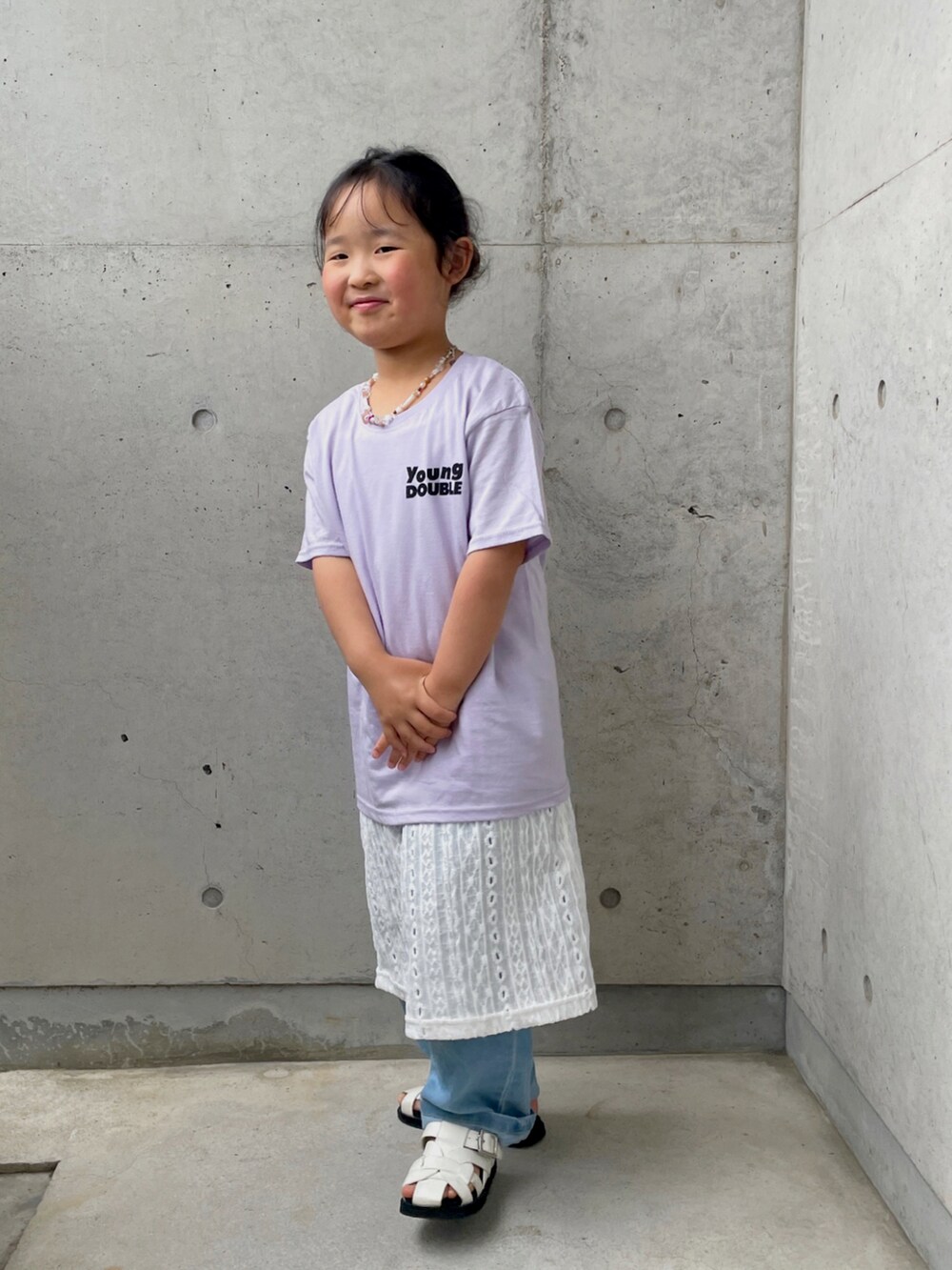 ホワイト系のサンダル、パープル系のTシャツ/カットソー、ホワイト系のワンピースを着用したキッズの春コーディネートの2枚目の写真
