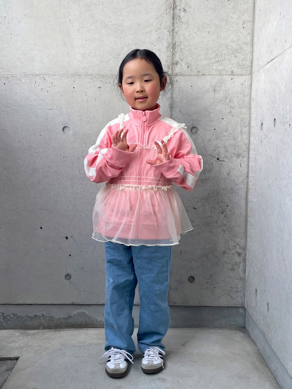 ピンク系のジャージ、ブラック系のTシャツ/カットソー、ホワイト系のスニーカーを着用したキッズの春コーディネートの2枚目の写真