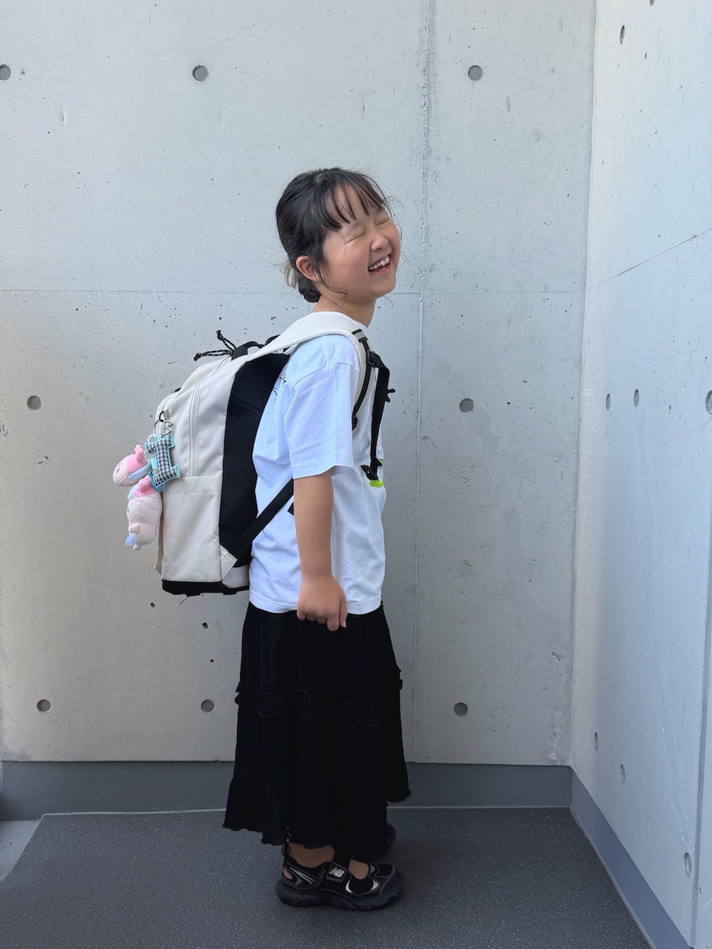 ブラック系のサンダル、ブラック系のスカート、ホワイト系のTシャツ/カットソーを着用したキッズの夏コーディネートの2枚目の写真
