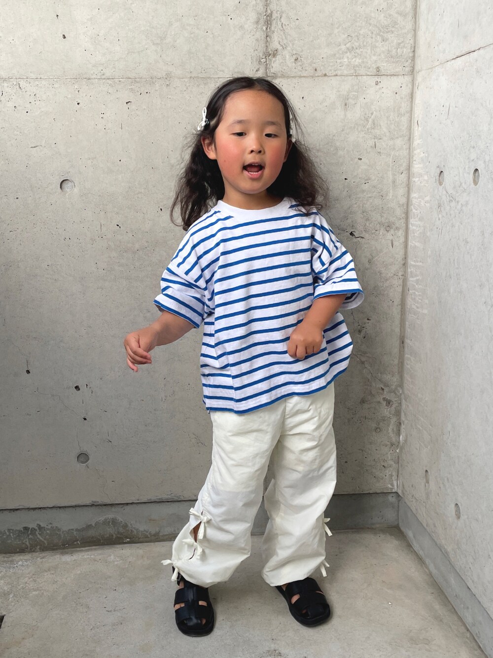 ブルー系のTシャツ/カットソー、ホワイト系のその他パンツ、ブラック系のサンダルを着用したキッズの春コーディネートの5枚目の写真