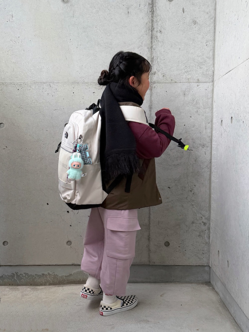 ホワイト系のTシャツ/カットソー、ピンク系のカーゴパンツ、ブラック系のスリッポンを着用したキッズの冬コーディネートの3枚目の写真