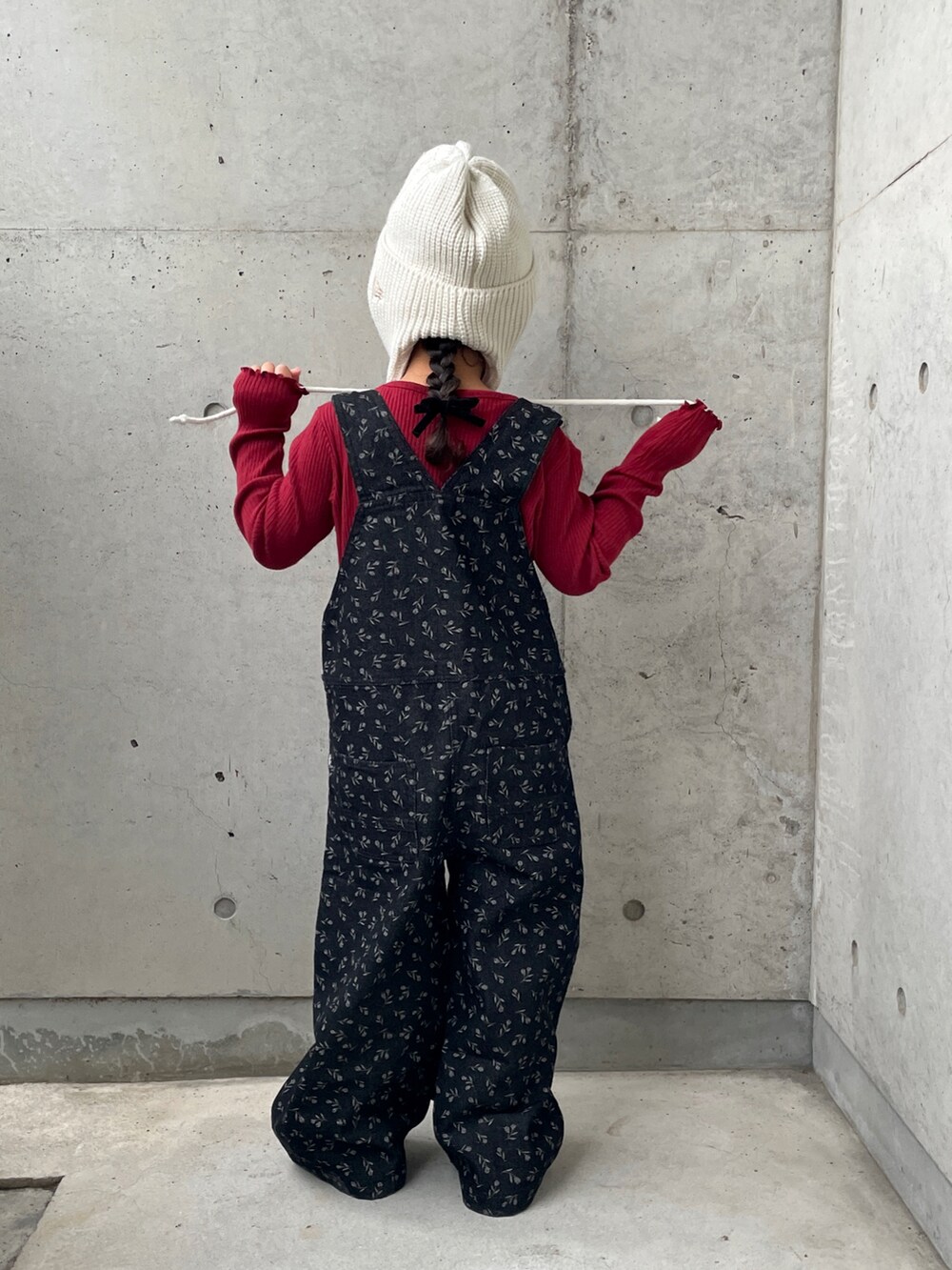 ブラウン系のブーツ、ブラック系のオールインワン・サロペット、ホワイト系のTシャツ/カットソーを着用したキッズの秋コーディネートの3枚目の写真