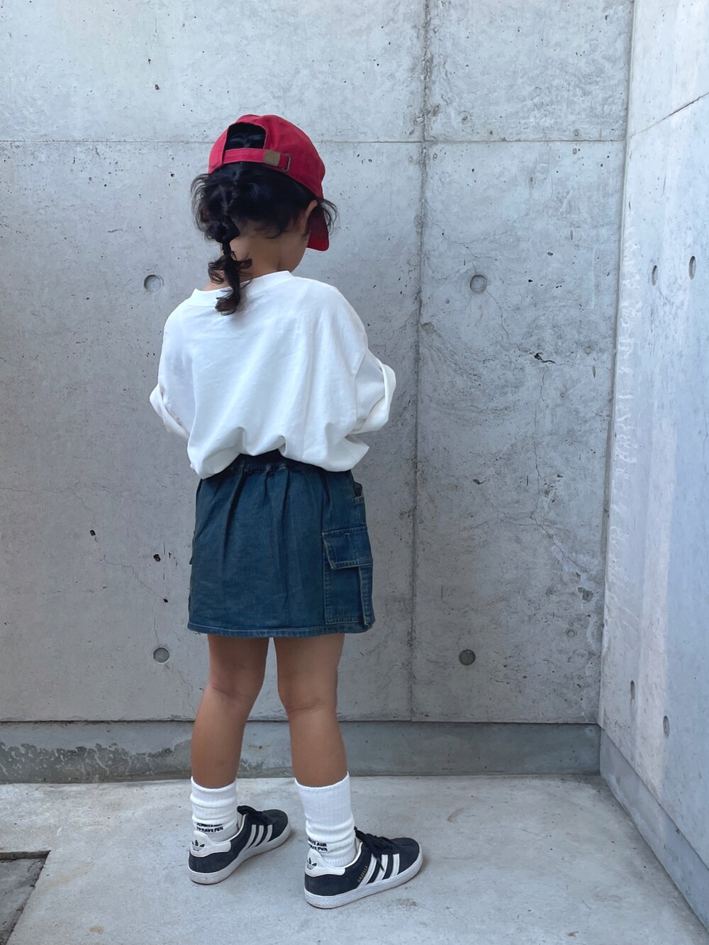 ブルー系のスカート、ブラック系のスニーカー、ホワイト系のTシャツ/カットソーを着用したキッズの夏コーディネートの5枚目の写真