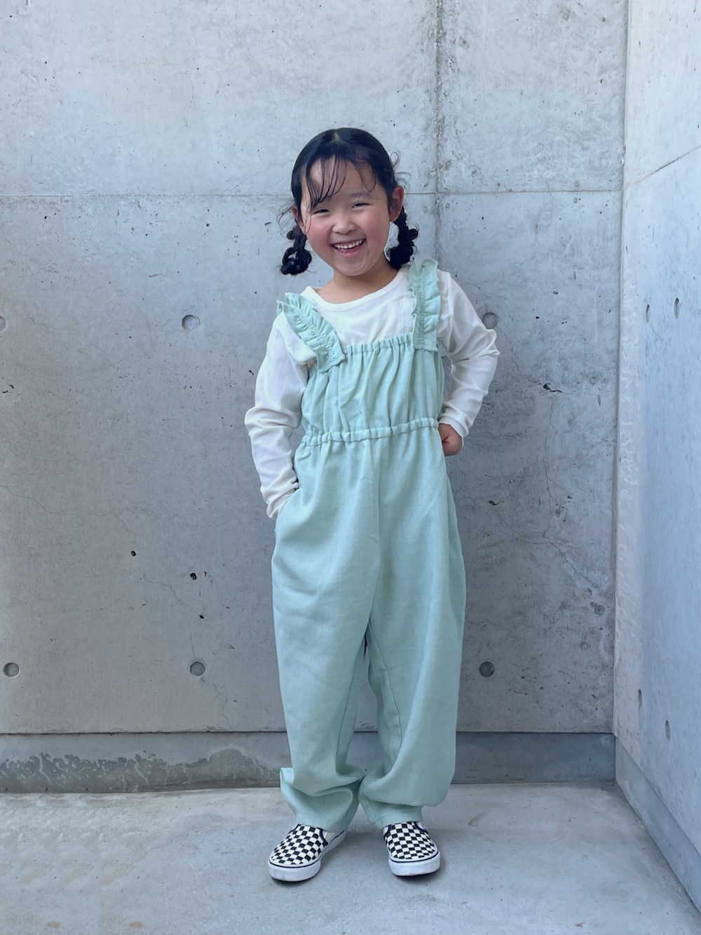 グリーン系のつなぎ/オールインワン、ブラック系のスリッポン、ブラック系のワンピース/ドレスを着用したキッズの秋コーディネートの3枚目の写真