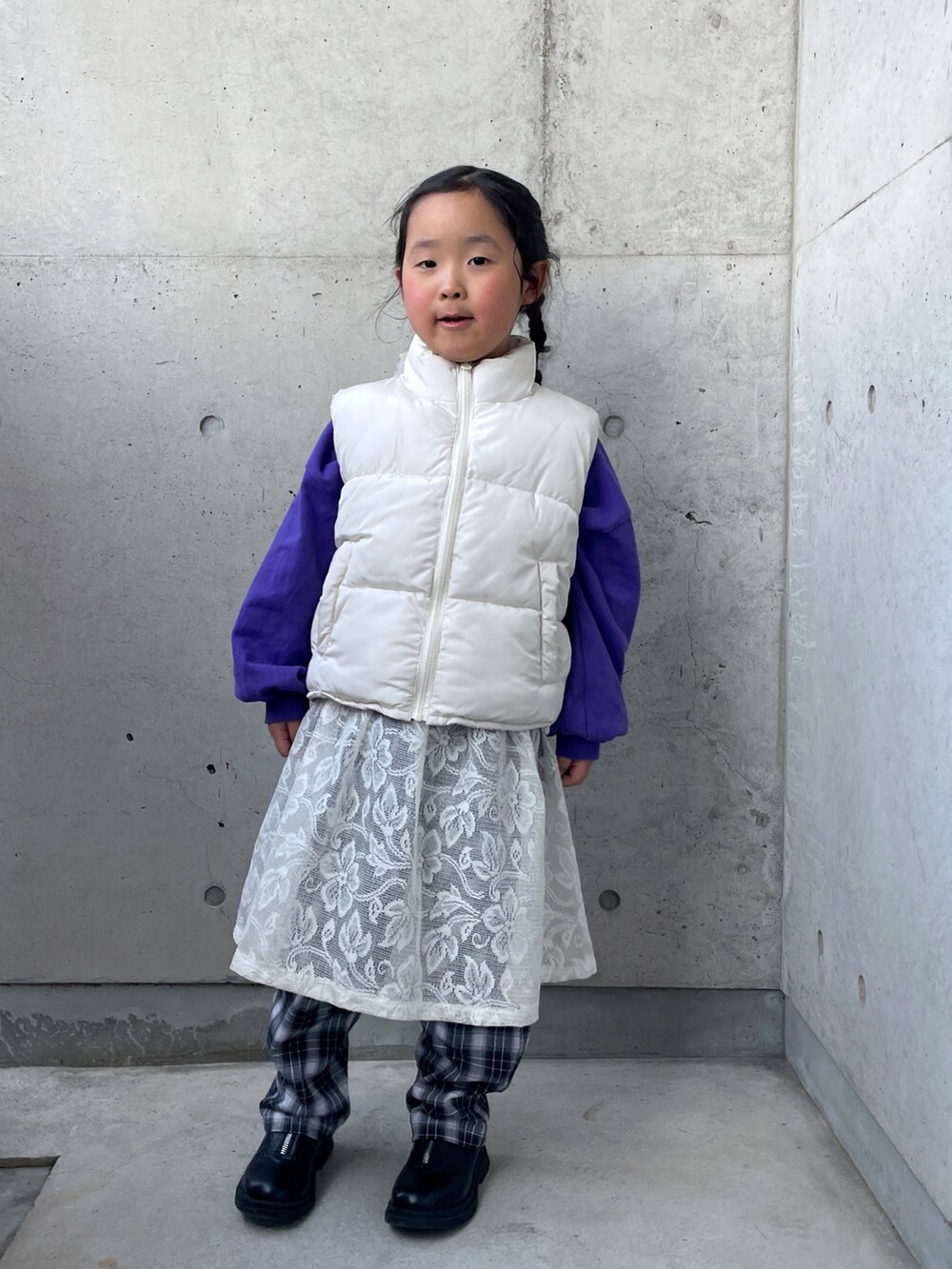 ホワイト系のスカート、パープル系のTシャツ/カットソー、ブラック系のブーツを着用したキッズの冬コーディネートの2枚目の写真