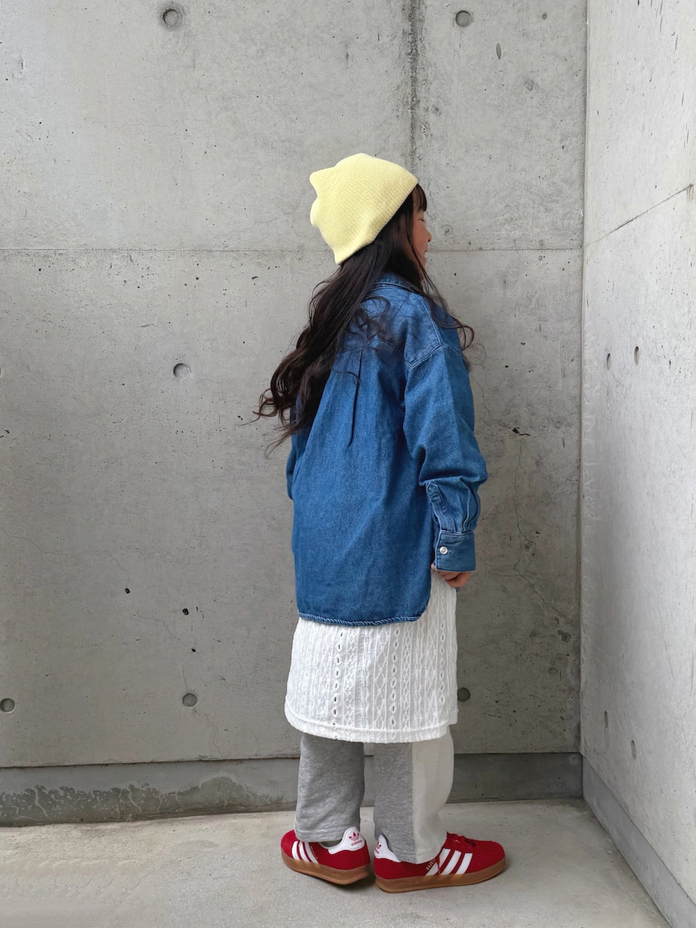 グレー系のスウェットパンツ、レッド系のスニーカー、ホワイト系のワンピースを着用したキッズの春コーディネートの3枚目の写真