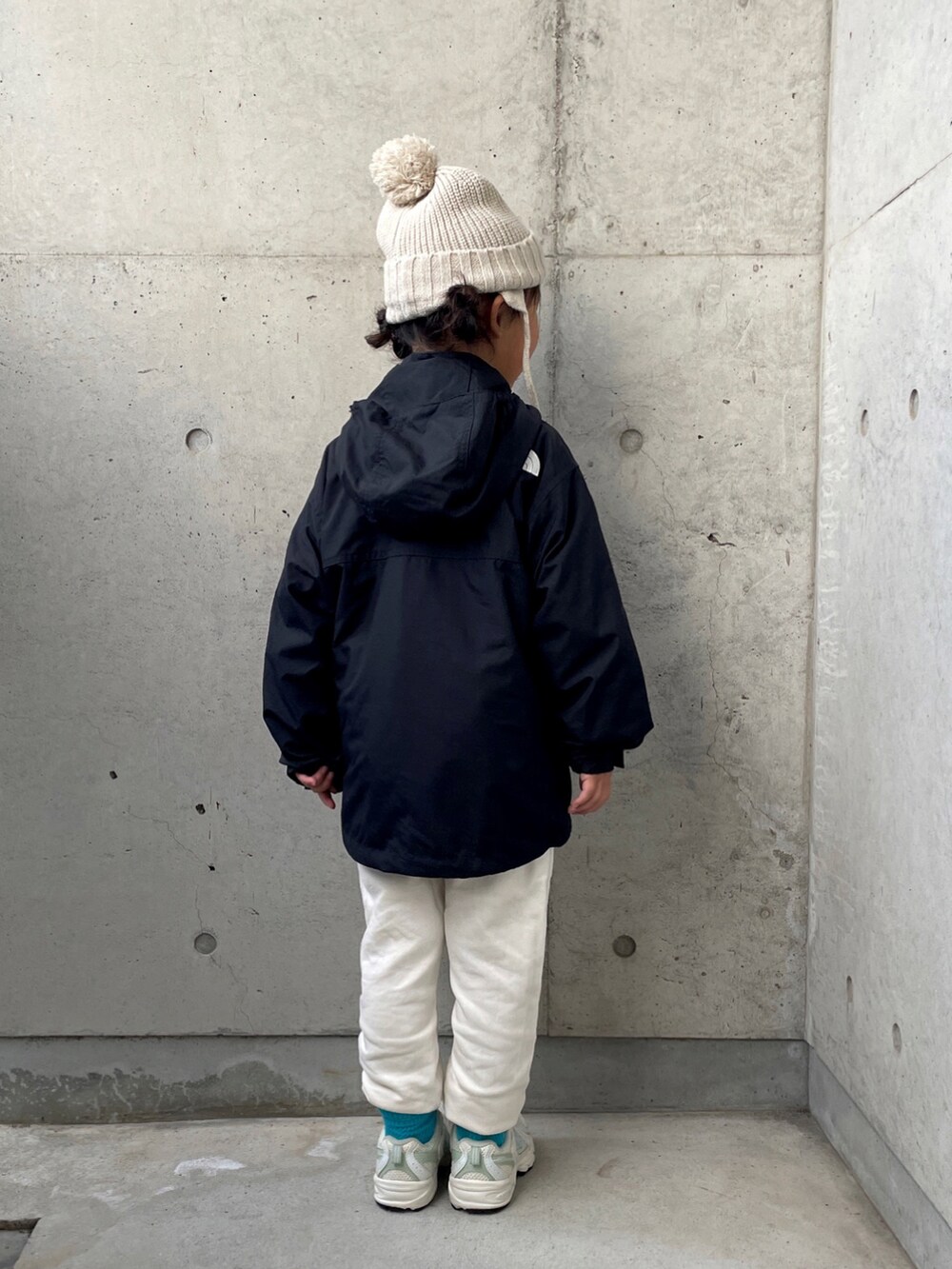 ブラック系のナイロンジャケット、ホワイト系のその他パンツ、ホワイト系のスウェットを着用したキッズの秋コーディネートの3枚目の写真