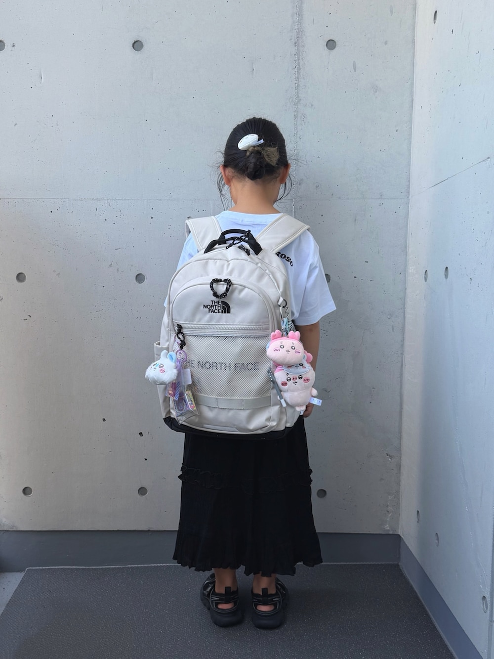 ブラック系のサンダル、ブラック系のスカート、ホワイト系のTシャツ/カットソーを着用したキッズの夏コーディネートの5枚目の写真
