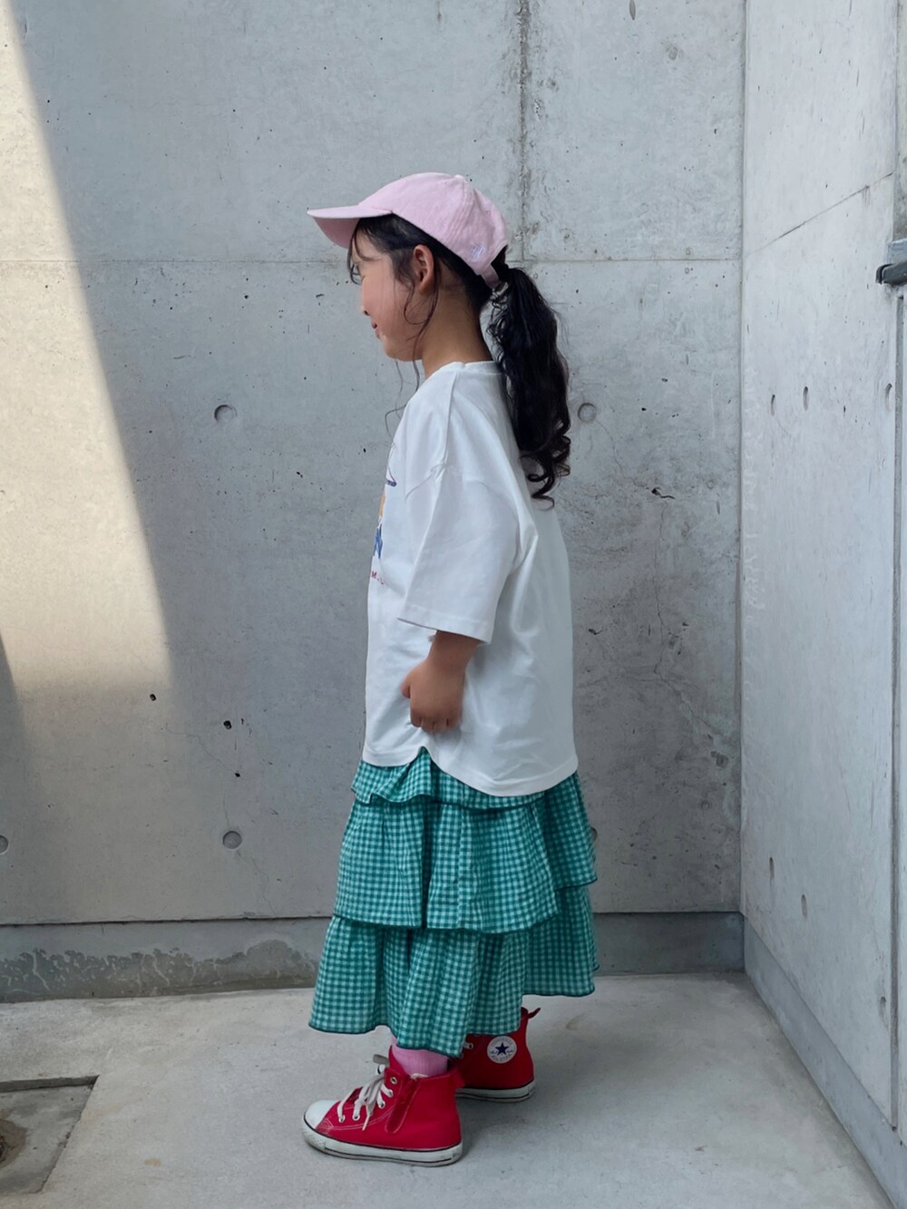 ホワイト系のTシャツ/カットソー、グリーン系のスカート、レッド系のスニーカーを着用したキッズの夏コーディネートの2枚目の写真