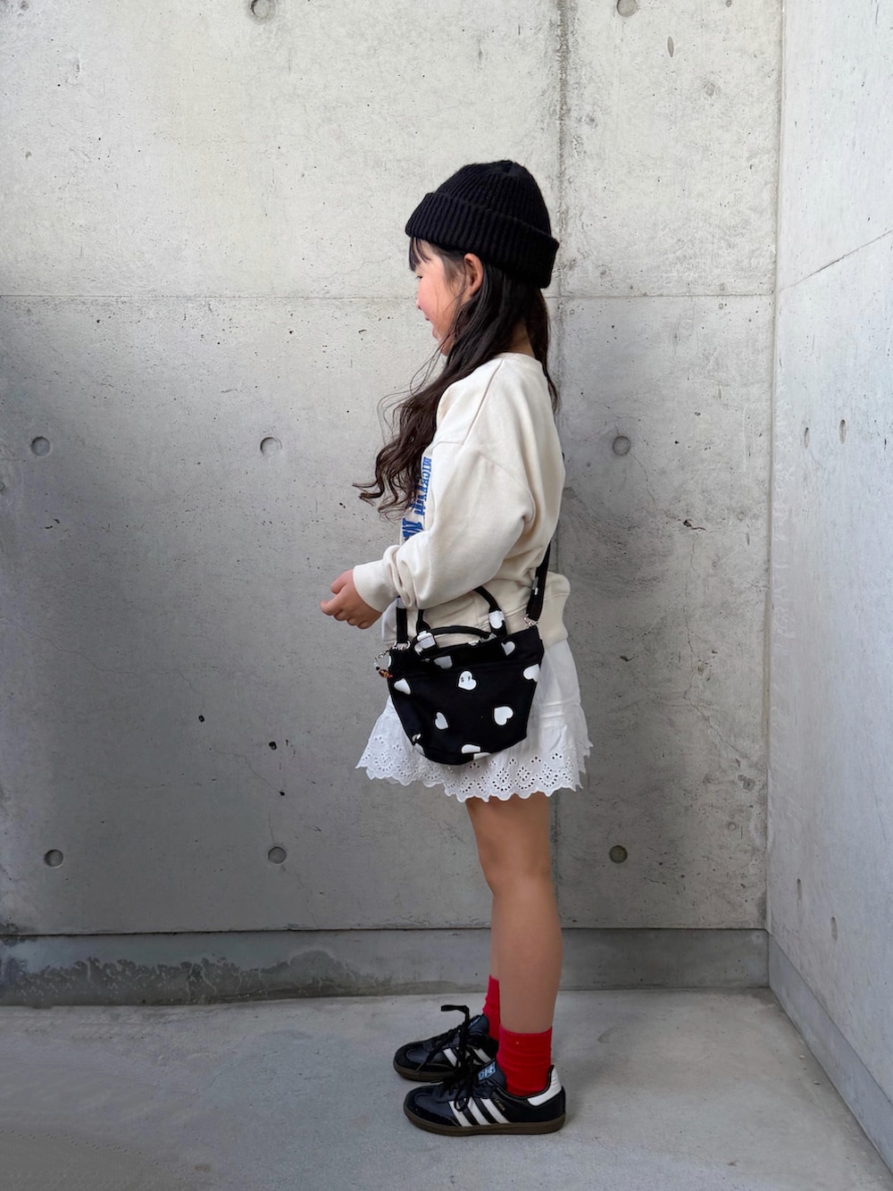 ホワイト系のスウェット、ブラック系のショルダーバッグ、ブラック系のスニーカーを着用したキッズの春コーディネートの2枚目の写真
