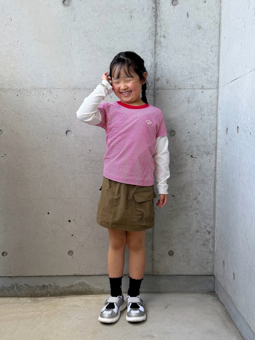 レッド系のTシャツ/カットソー、グリーン系のスカート、ホワイト系のバッグを着用したキッズの春コーディネートの5枚目の写真