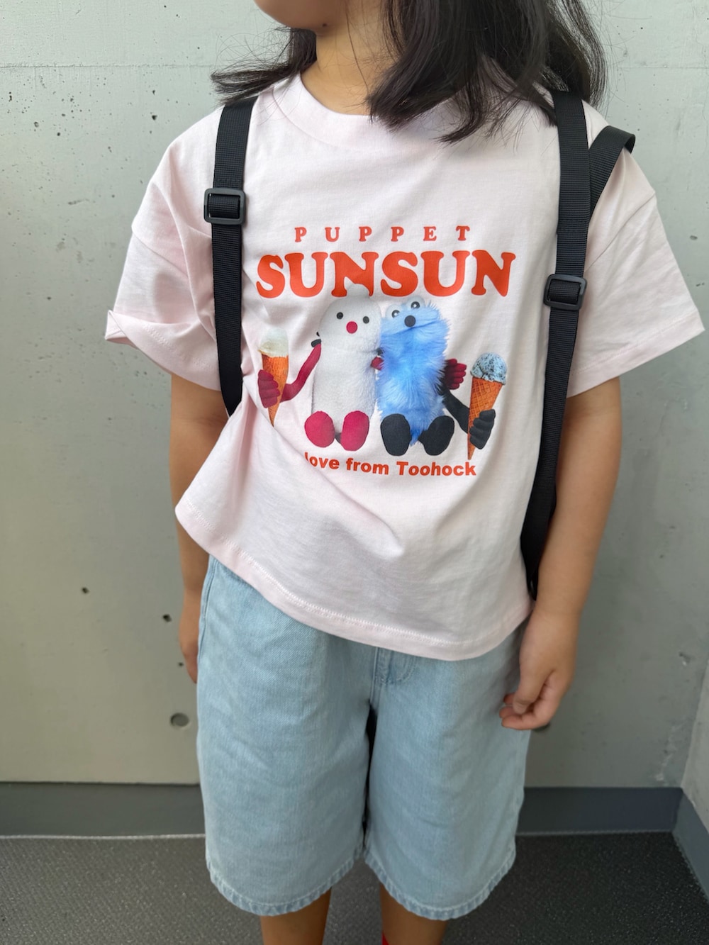 ブラック系のサンダル、ブラック系のバックパック/リュック、ピンク系のTシャツ/カットソーを着用したキッズの秋コーディネートの5枚目の写真