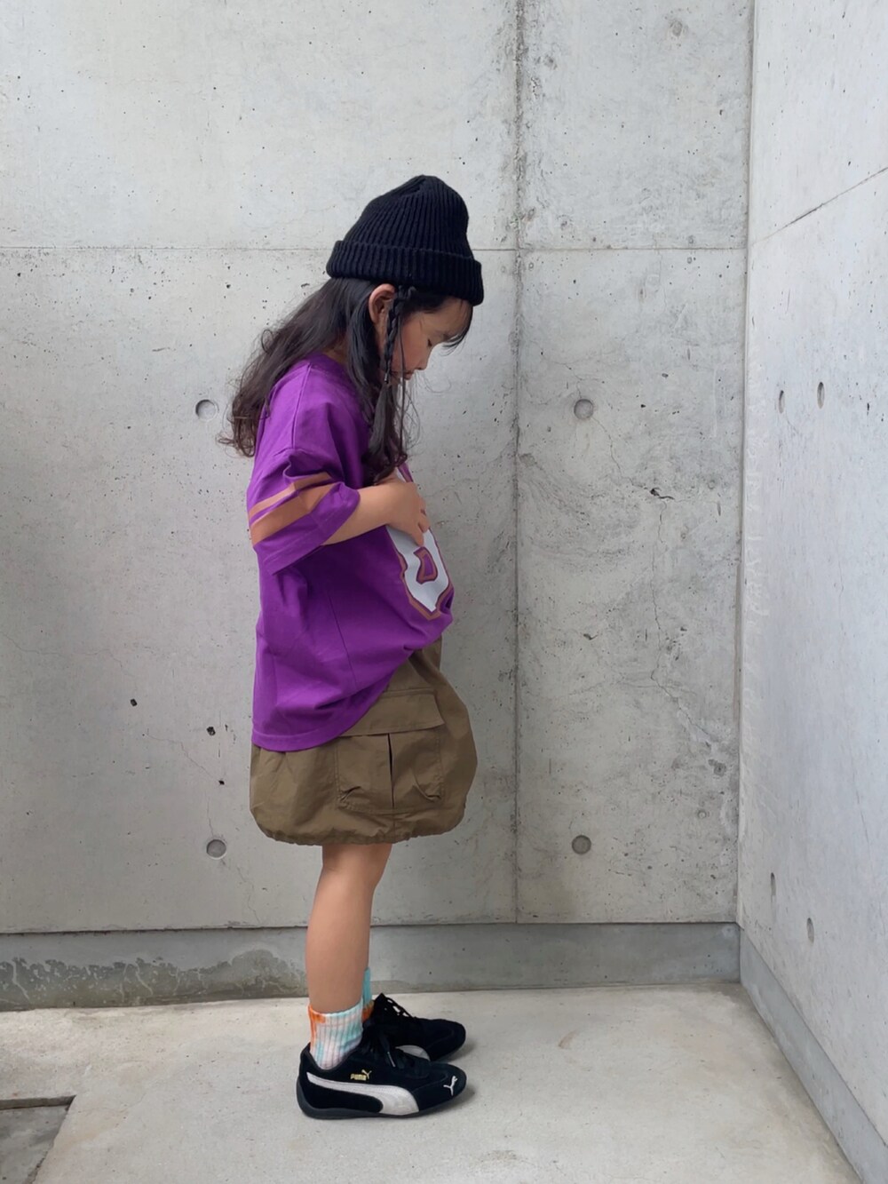 パープル系のTシャツ/カットソー、グリーン系のスカート、ブラック系のスニーカーを着用したキッズの春コーディネートの2枚目の写真