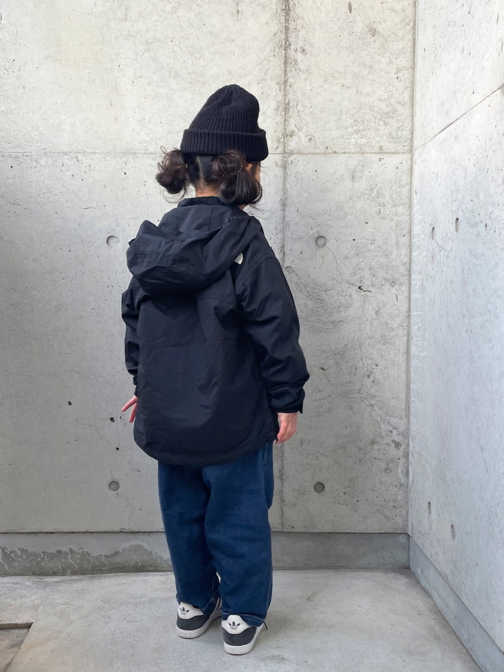 ブラック系のナイロンジャケット、グレー系のスウェット、ブルー系のデニムパンツを着用したキッズの冬コーディネートの3枚目の写真