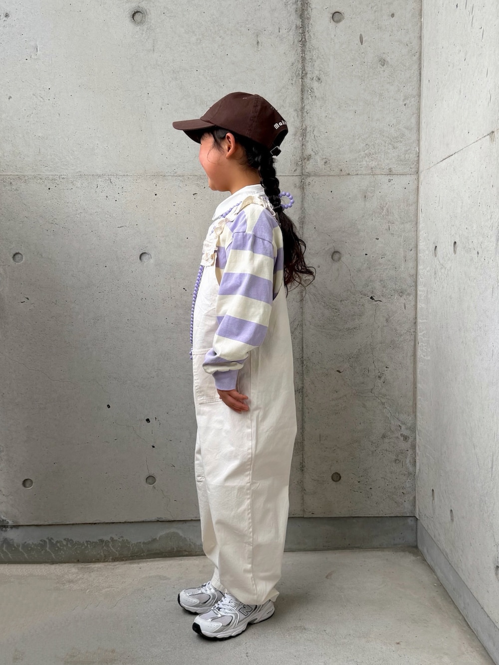 パープル系のTシャツ/カットソー、ホワイト系のサロペット/オーバーオール、ホワイト系のスニーカーを着用したキッズの春コーディネートの2枚目の写真