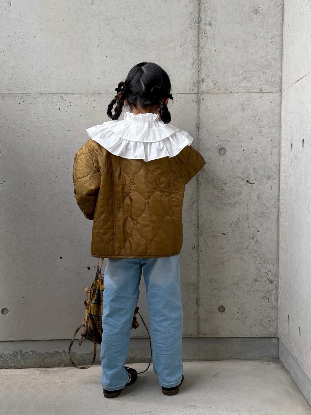 ブラック系のスニーカー、ブルー系のデニムパンツ、イエロー系のバックパック/リュックを着用したキッズの秋コーディネートの4枚目の写真