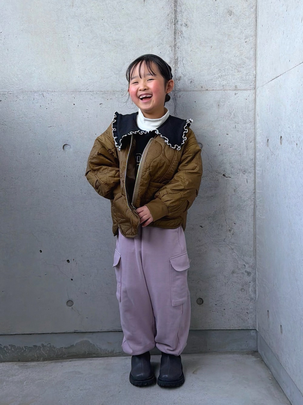ブラック系のスウェット、ピンク系のカーゴパンツ、グレー系のブーツを着用したキッズの冬コーディネートの5枚目の写真