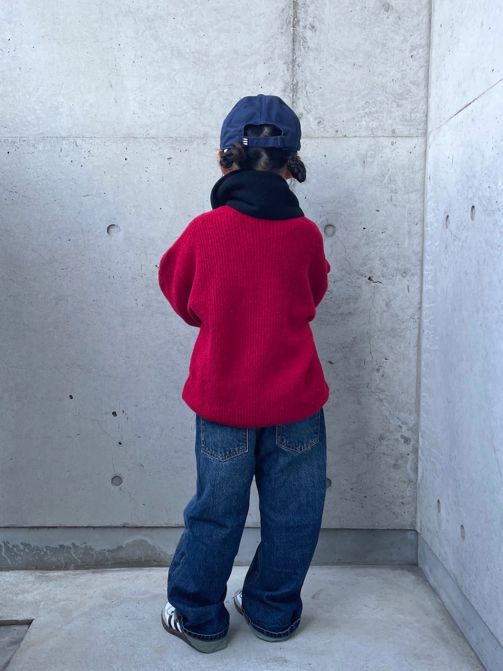 レッド系のニット/セーター、ブルー系のデニムパンツ、グリーン系のブルゾンを着用したキッズの冬コーディネートの4枚目の写真