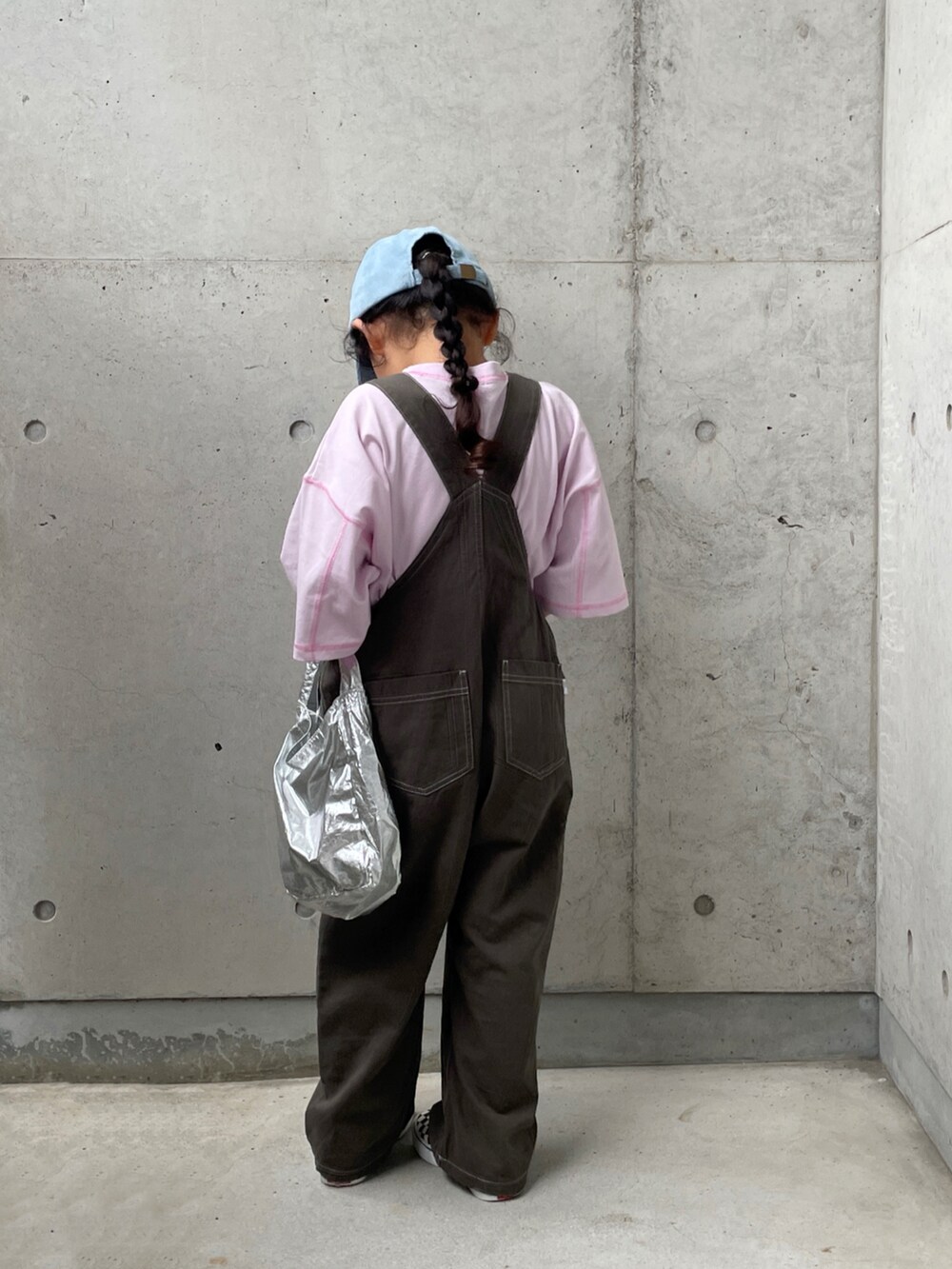 グレー系のサロペット/オーバーオール、ブラック系のスリッポン、パープル系のTシャツ/カットソーを着用したキッズの秋コーディネートの5枚目の写真