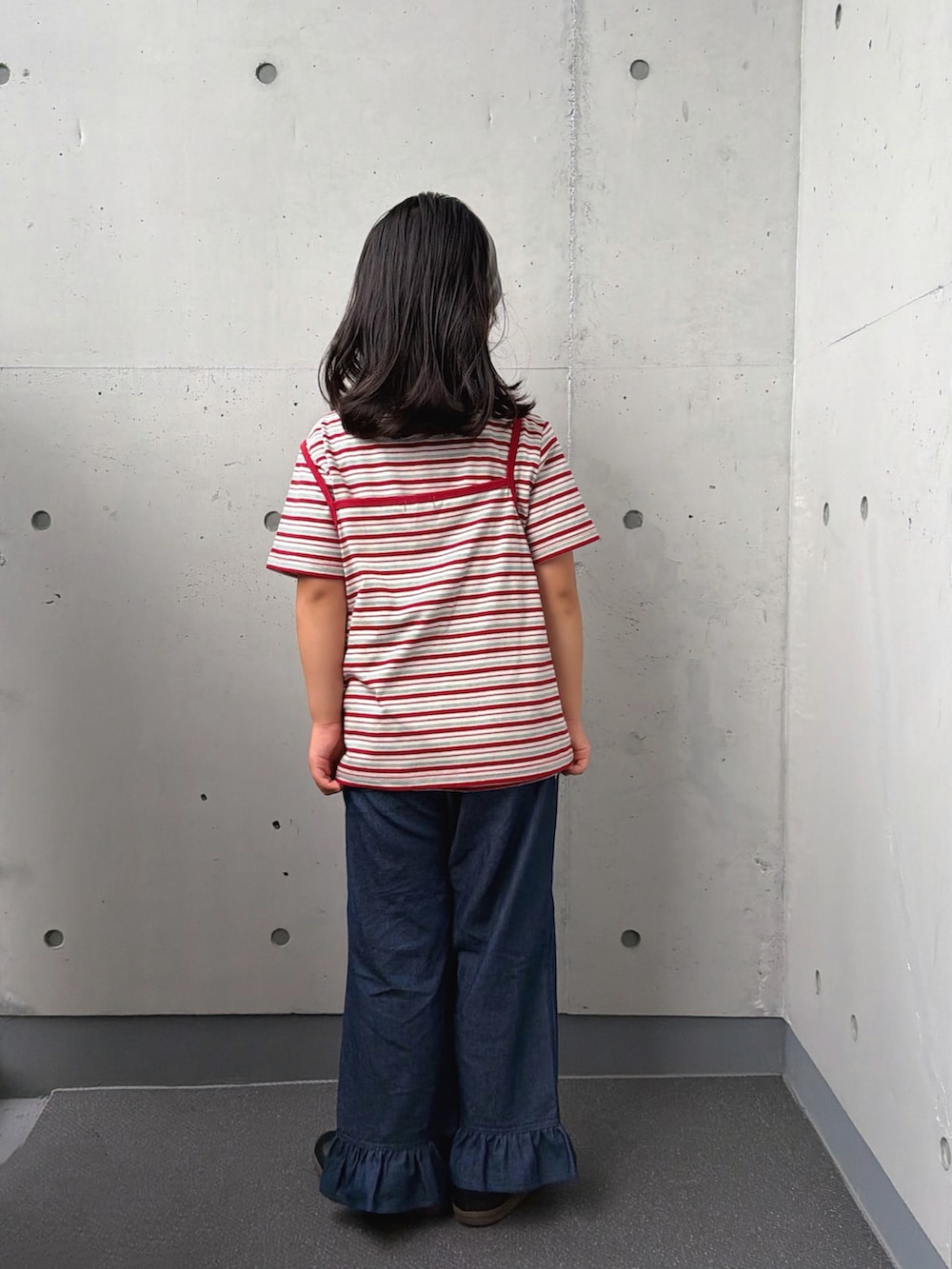 ホワイト系のTシャツ/カットソー、ブルー系のデニムパンツ、ブラック系のスニーカーを着用したキッズの秋コーディネートの5枚目の写真