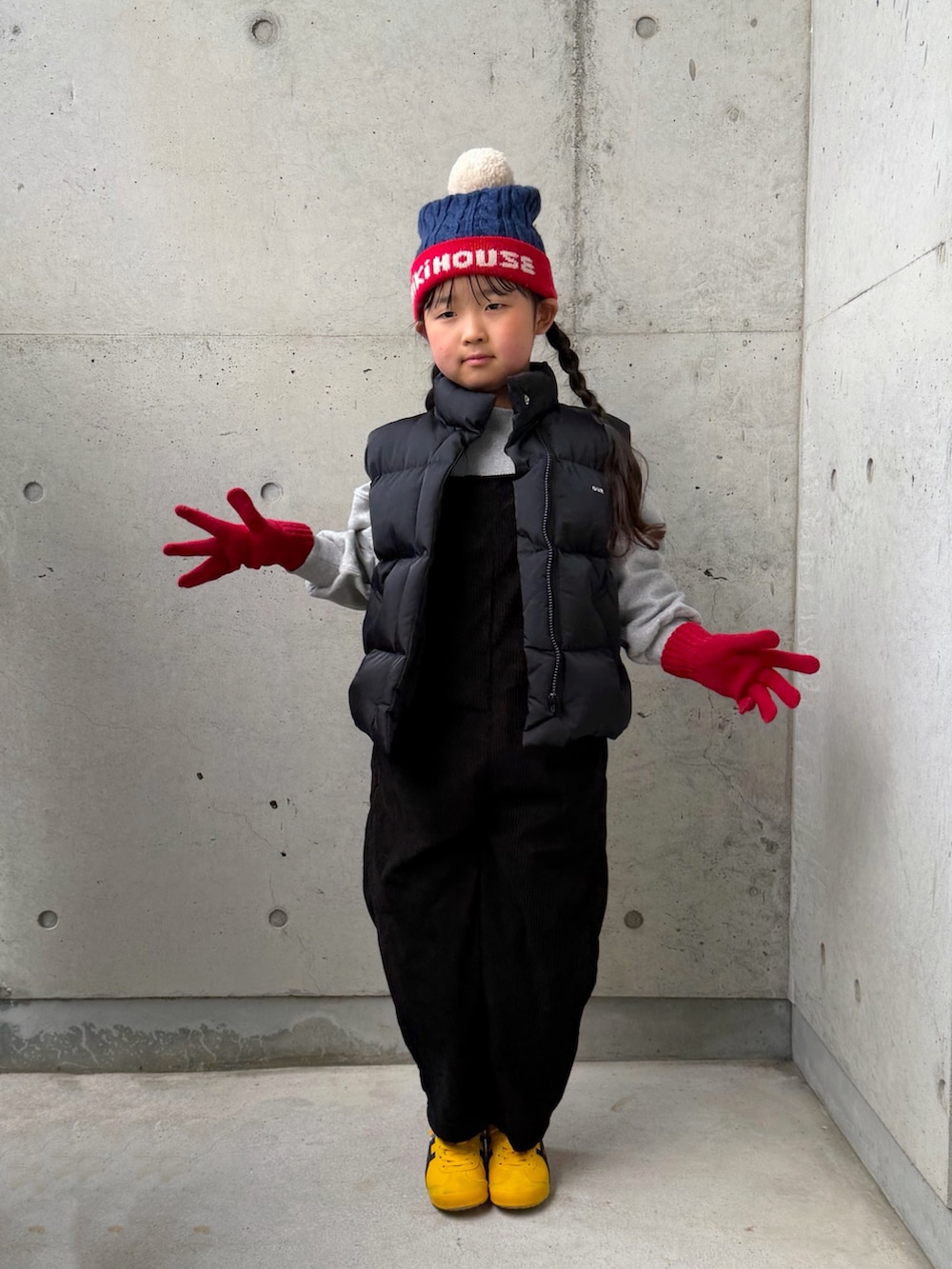 グレー系のスウェット、イエロー系のスニーカー、ブラック系のサロペット/オーバーオールを着用したキッズの冬コーディネートの3枚目の写真