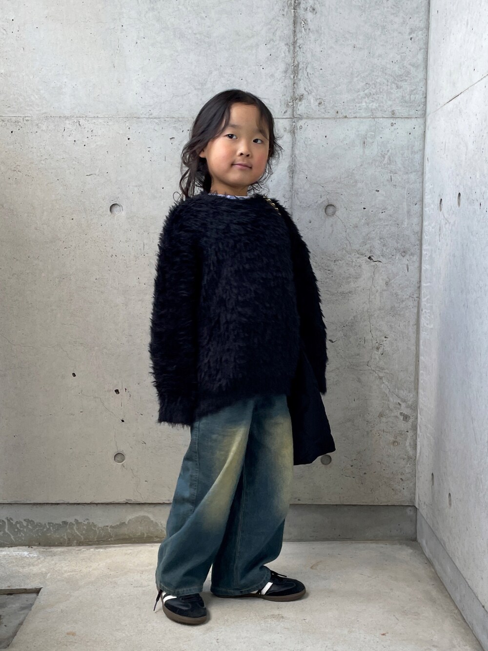 ブラック系のニット/セーター、ブルー系のパンツ、ホワイト系のTシャツ/カットソーを着用したキッズの冬コーディネートの2枚目の写真