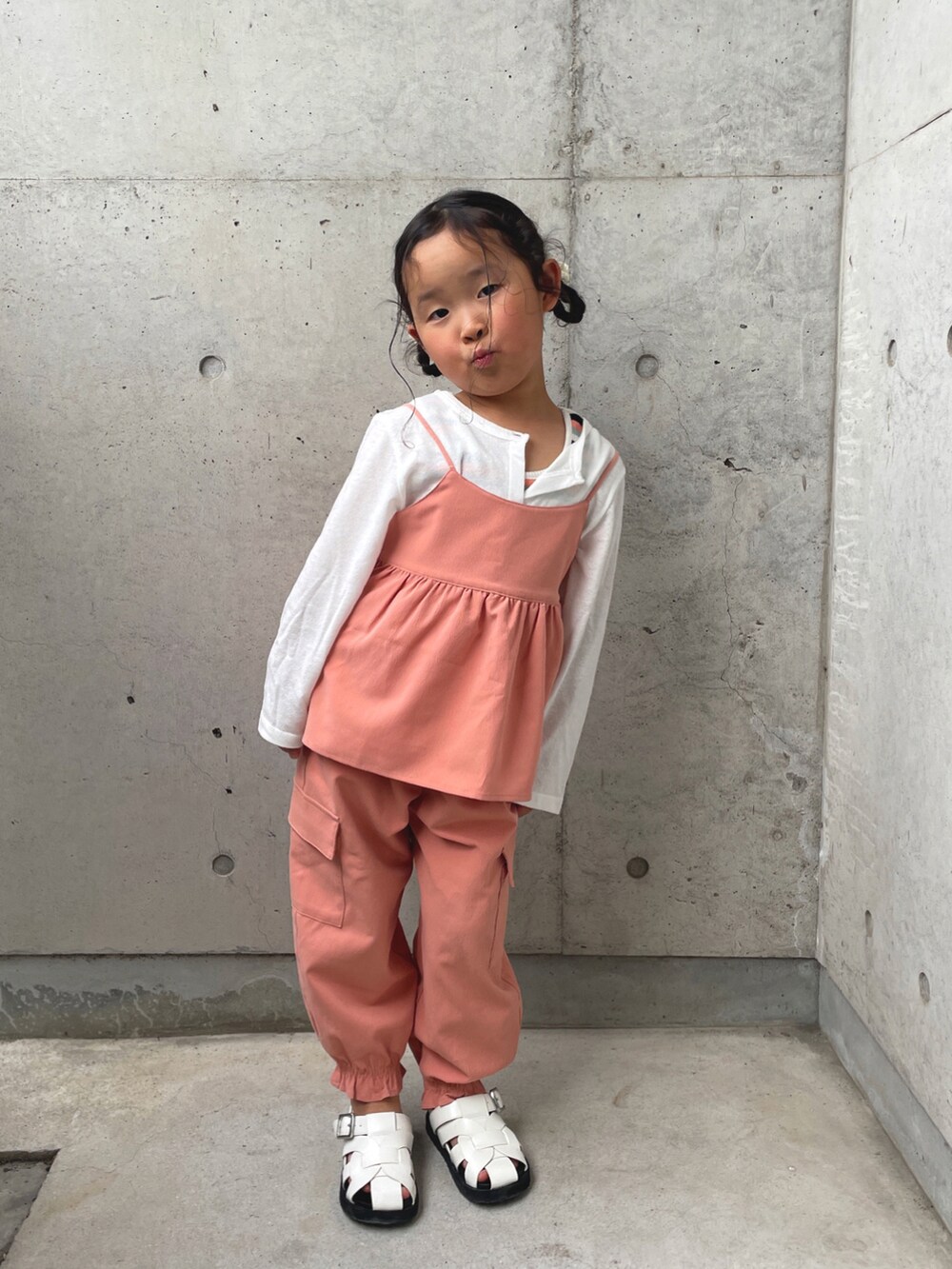 オレンジ系のTシャツ/カットソー、オレンジ系のその他パンツ、ホワイト系のサンダルを着用したキッズの春コーディネートの3枚目の写真