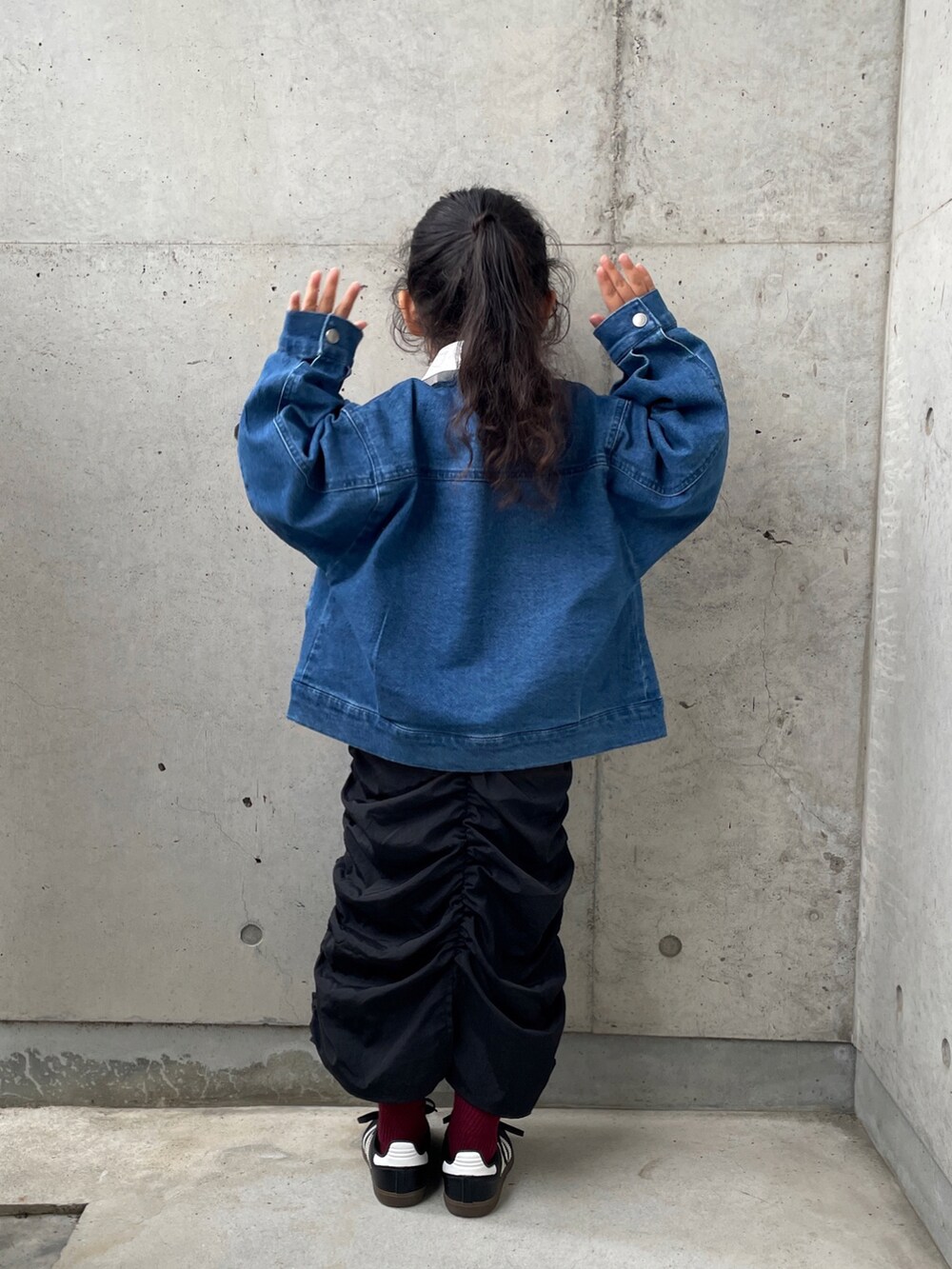 ピンク系のTシャツ/カットソー、ブルー系のデニムジャケット、ブラック系のスカートを着用したキッズの秋コーディネートの2枚目の写真