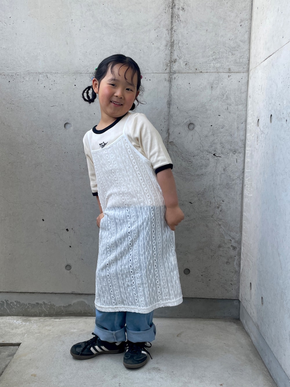 ホワイト系のワンピース、ホワイト系のTシャツ/カットソー、ブルー系のデニムパンツを着用したキッズの春コーディネートの3枚目の写真
