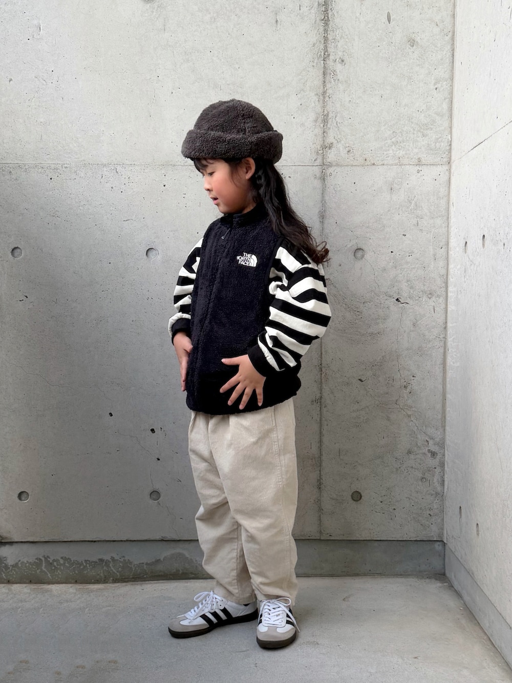 ホワイト系のスニーカー、ベージュ系のその他パンツ、ブラック系のベストを着用したキッズの秋コーディネートの5枚目の写真