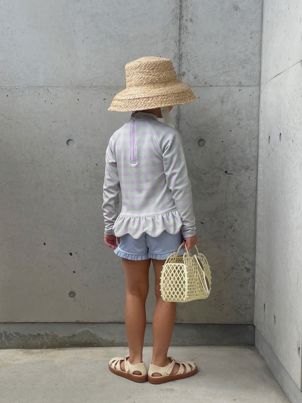 ホワイト系のサンダル、ホワイト系のバッグ、ホワイト系のハットを着用したキッズの夏コーディネートの2枚目の写真