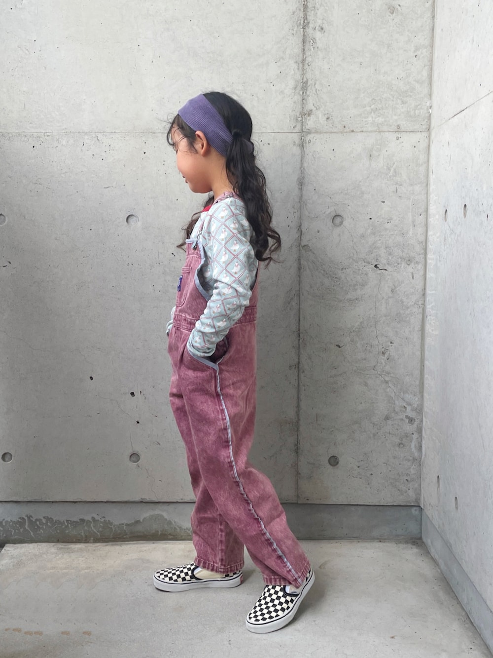 ブラック系のスリッポン、ブルー系のトップス、レッド系のサロペット/オーバーオールを着用したキッズの秋コーディネートの2枚目の写真