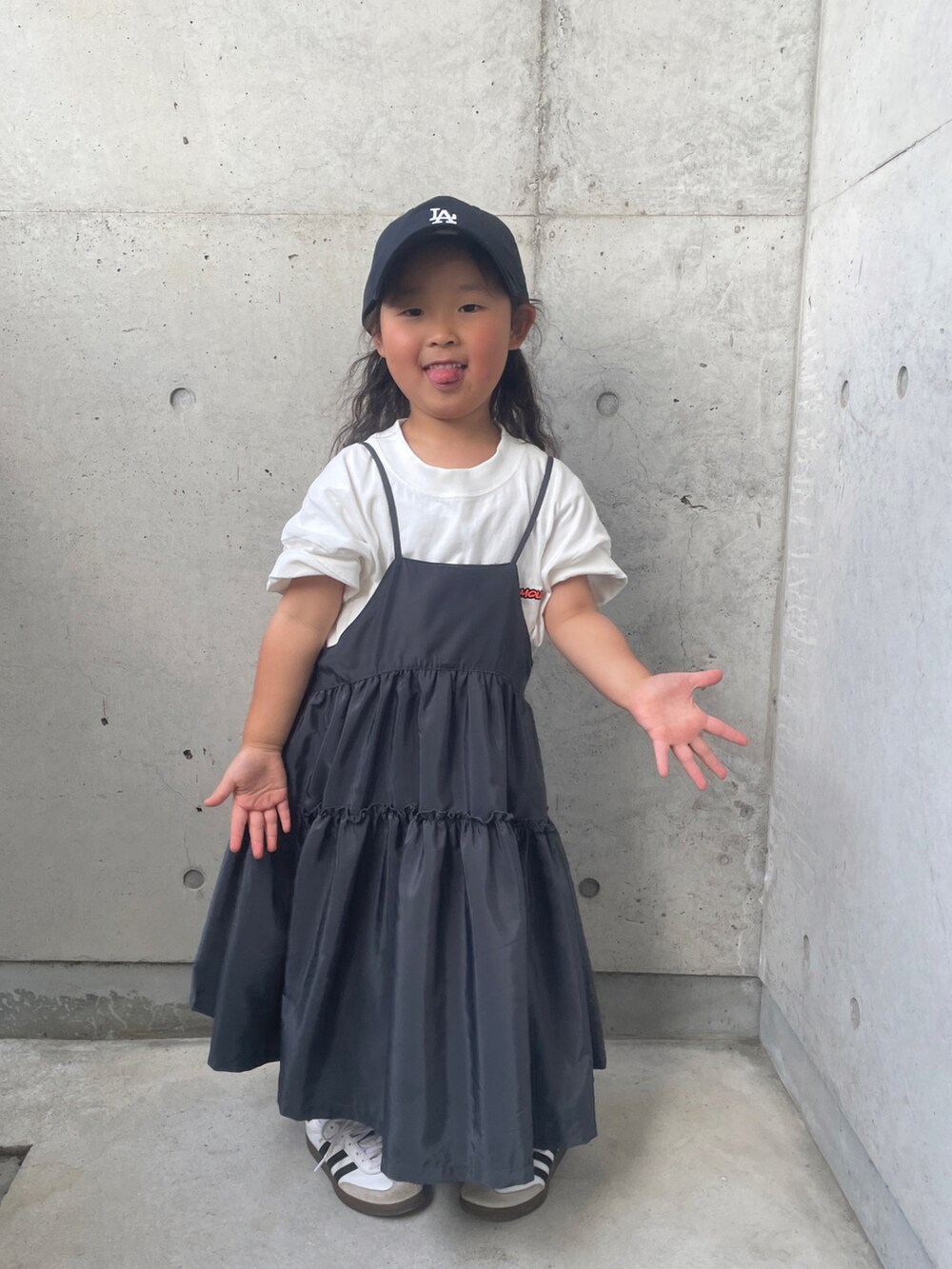 ホワイト系のスニーカー、グレー系のワンピース、ホワイト系のTシャツ/カットソーを着用したキッズの春コーディネートの2枚目の写真