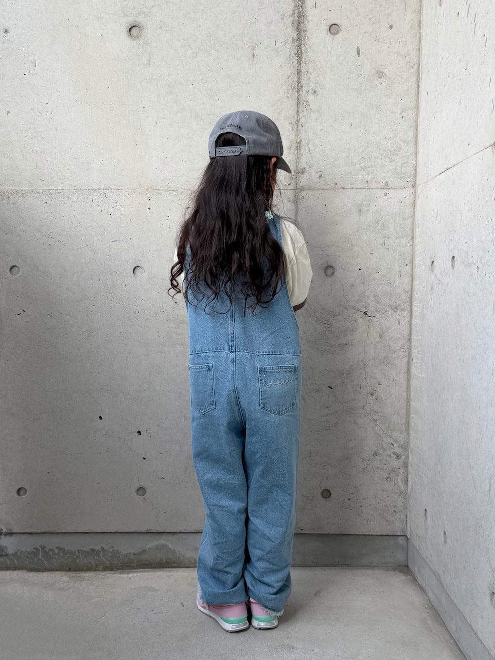 ブルー系のサロペット/オーバーオール、ピンク系のスニーカー、ホワイト系のTシャツ/カットソーを着用したキッズの春コーディネートの5枚目の写真