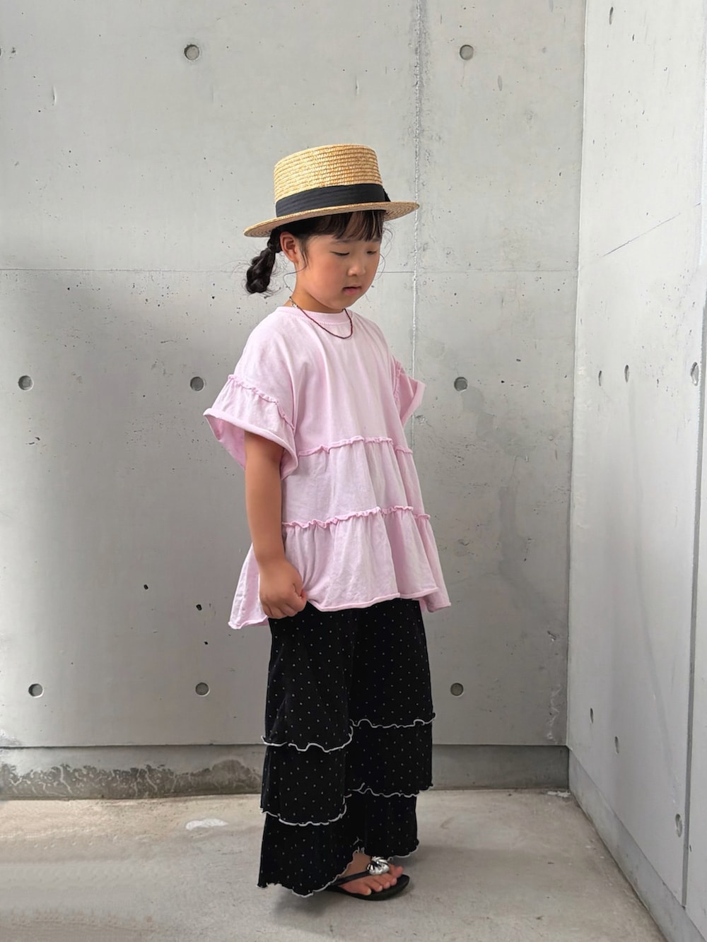 ピンク系のTシャツ/カットソー、ブラック系のその他パンツ、ブラック系のサンダルを着用したキッズの夏コーディネートの2枚目の写真