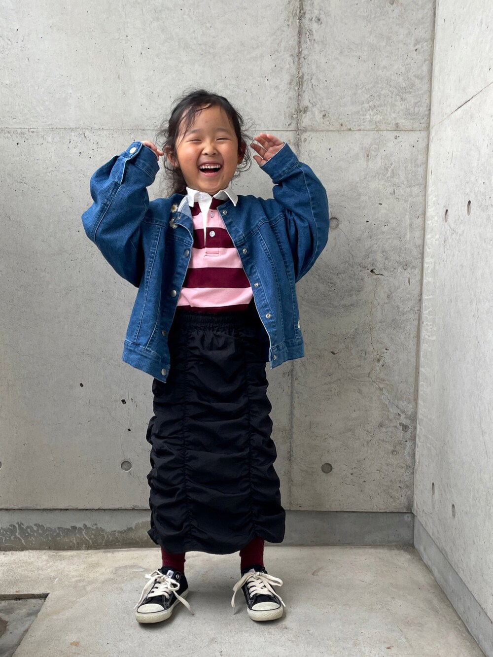 ピンク系のTシャツ/カットソー、ブルー系のデニムジャケット、ブラック系のスカートを着用したキッズの秋コーディネートの3枚目の写真