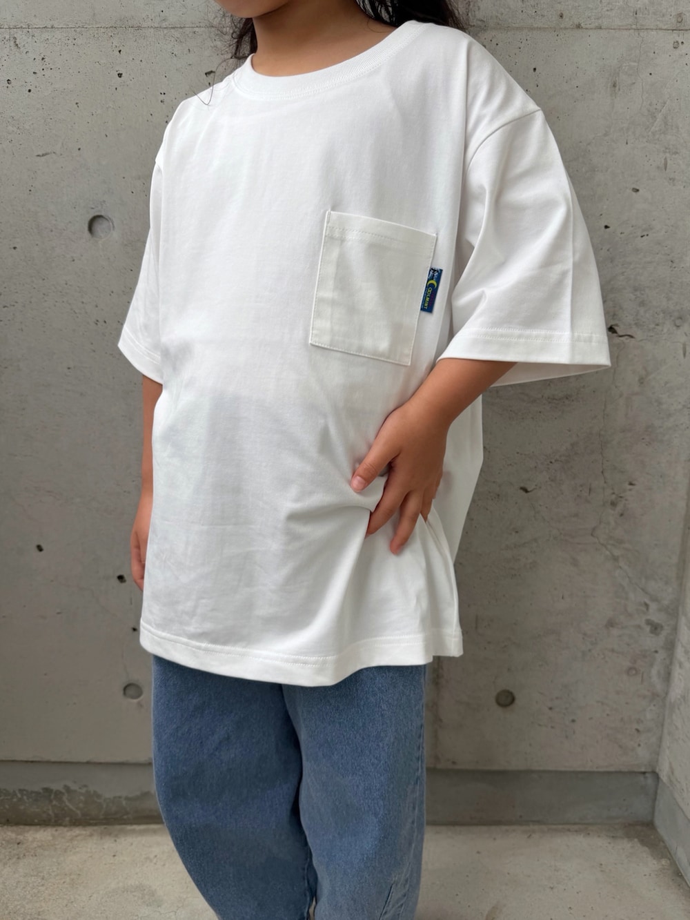 ホワイト系のTシャツ/カットソー、ホワイト系のサンダル、ブルー系のパンツを着用したキッズの春コーディネートの5枚目の写真