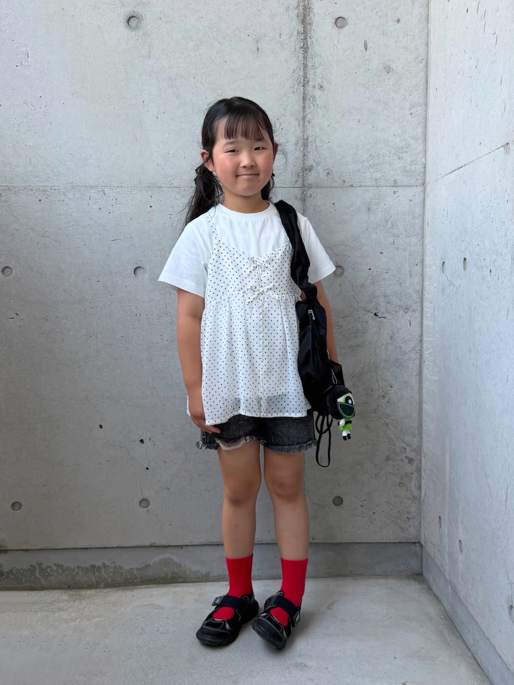 ブラック系のデニムパンツ、ホワイト系のTシャツ/カットソー、ブラック系のサンダルを着用したキッズの夏コーディネートの2枚目の写真