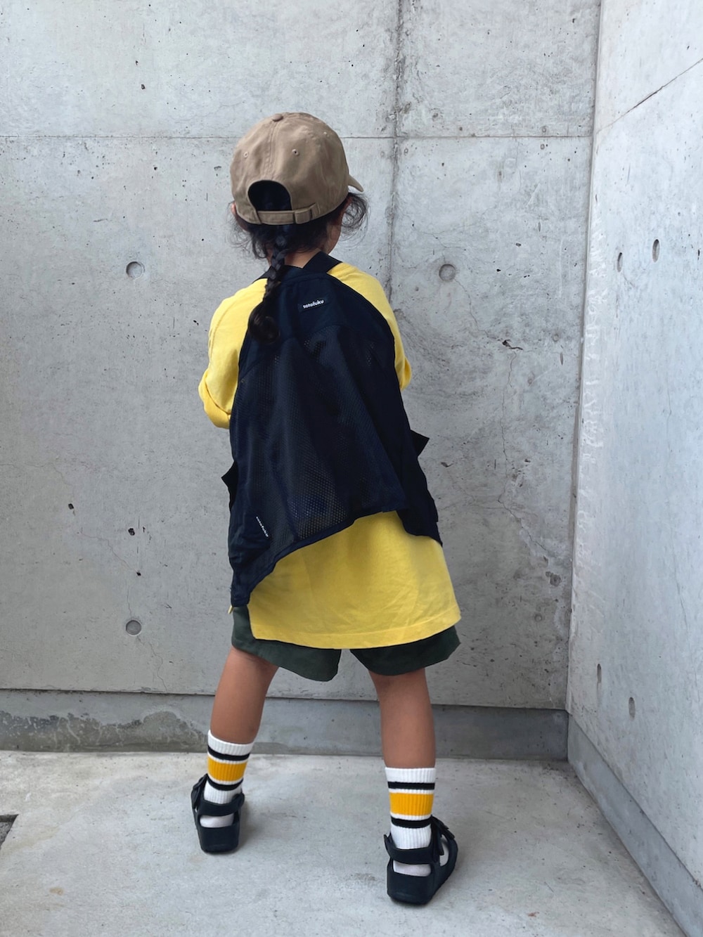 ブラック系のサンダル、ブラック系のベスト、グリーン系のパンツを着用したキッズの夏コーディネートの4枚目の写真