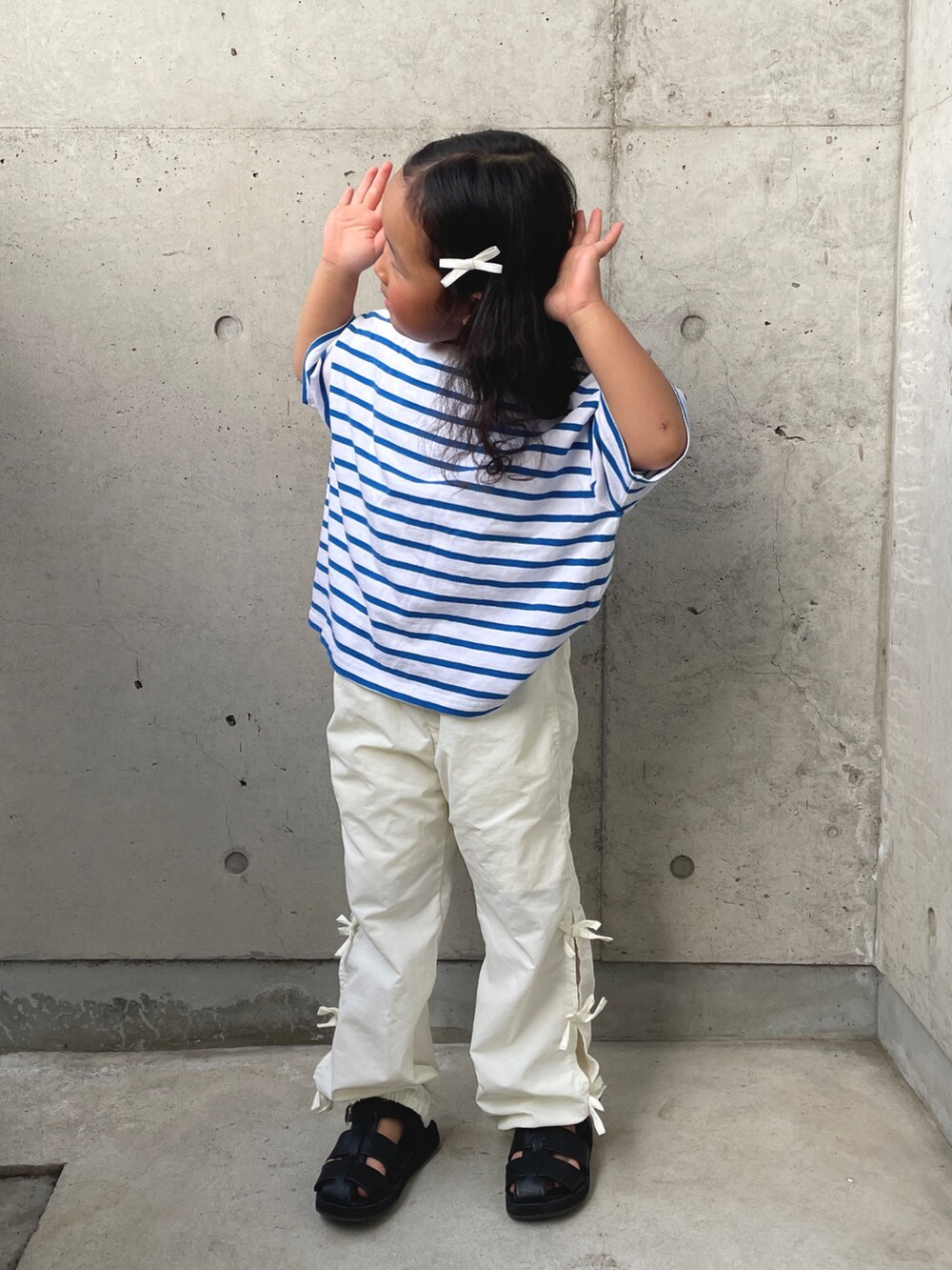 ブルー系のTシャツ/カットソー、ホワイト系のその他パンツ、ブラック系のサンダルを着用したキッズの春コーディネートの2枚目の写真