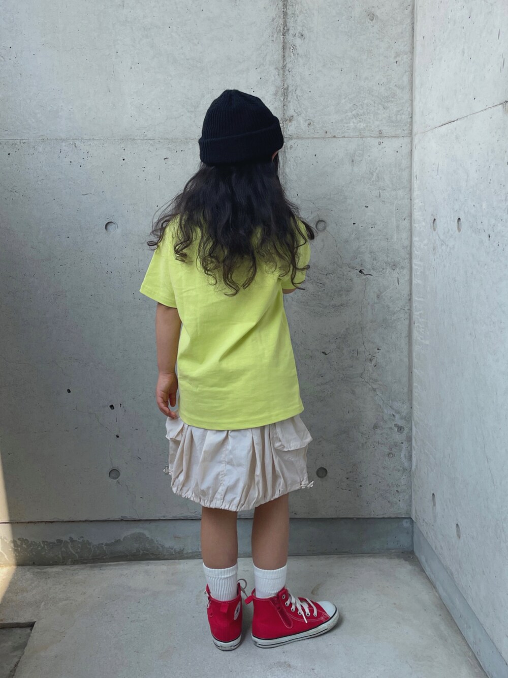 レッド系のスニーカー、イエロー系のTシャツ/カットソー、ホワイト系のスカートを着用したキッズの夏コーディネートの2枚目の写真