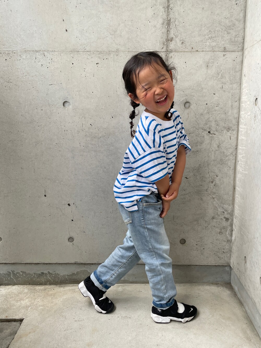 ブルー系のTシャツ/カットソー、ブラック系のスニーカー、ブルー系のデニムパンツを着用したキッズの春コーディネートの5枚目の写真