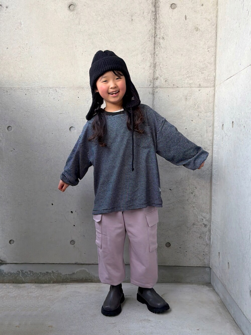ピンク系のカーゴパンツ、グレー系のブーツ、ブラック系のTシャツ/カットソーを着用したキッズの冬コーディネートの4枚目の写真