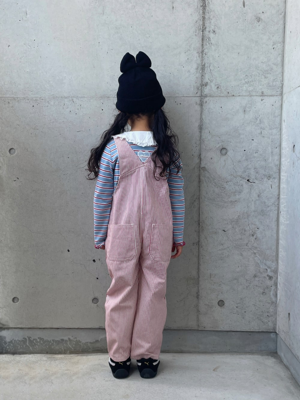 ブラック系のスニーカー、ブルー系のトップス、レッド系のオールインワン・サロペットを着用したキッズの夏コーディネートの3枚目の写真