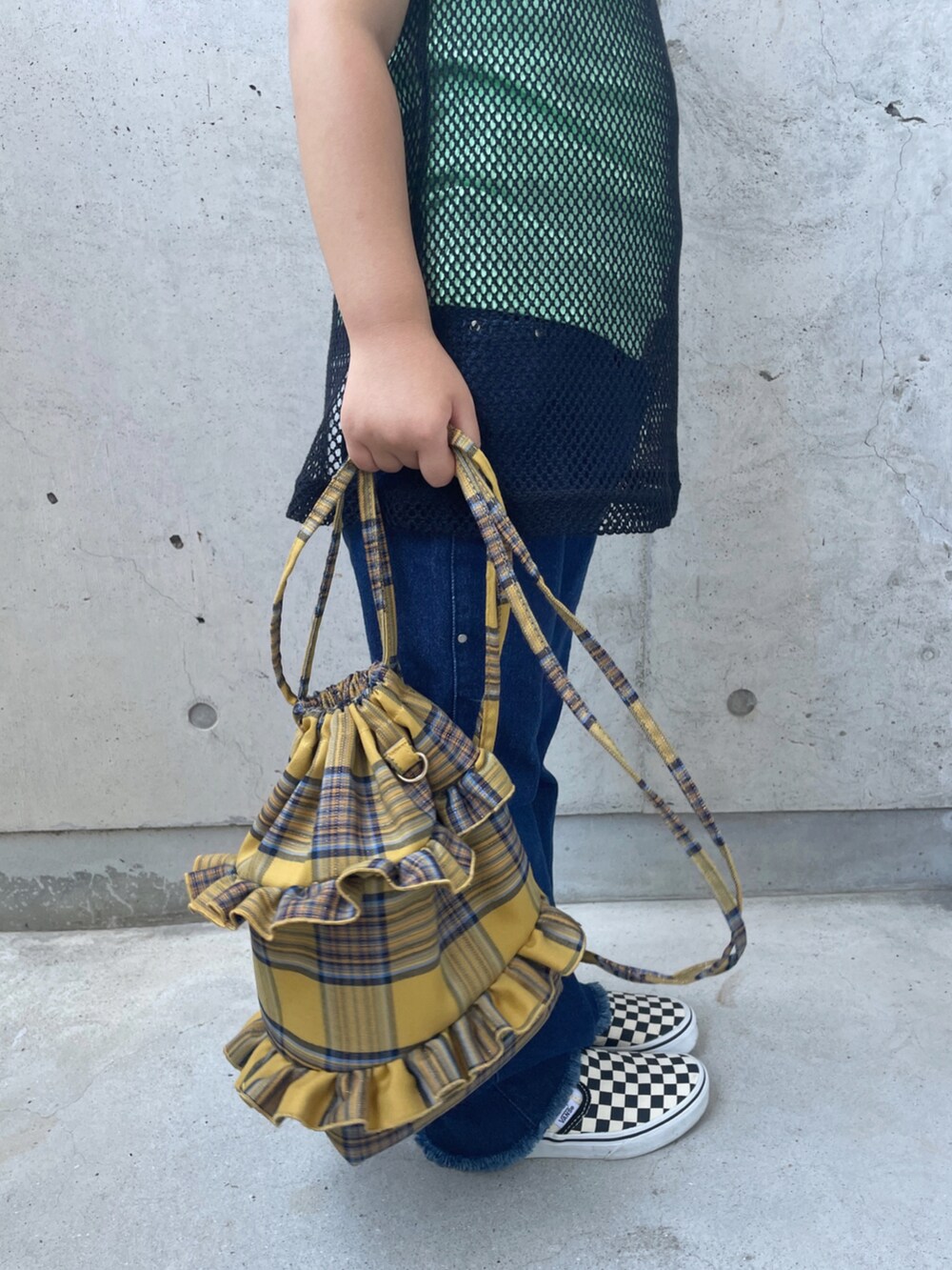 ブラック系のタンクトップ、ブルー系のデニムパンツ、イエロー系のバックパック/リュックを着用したキッズの夏コーディネートの5枚目の写真