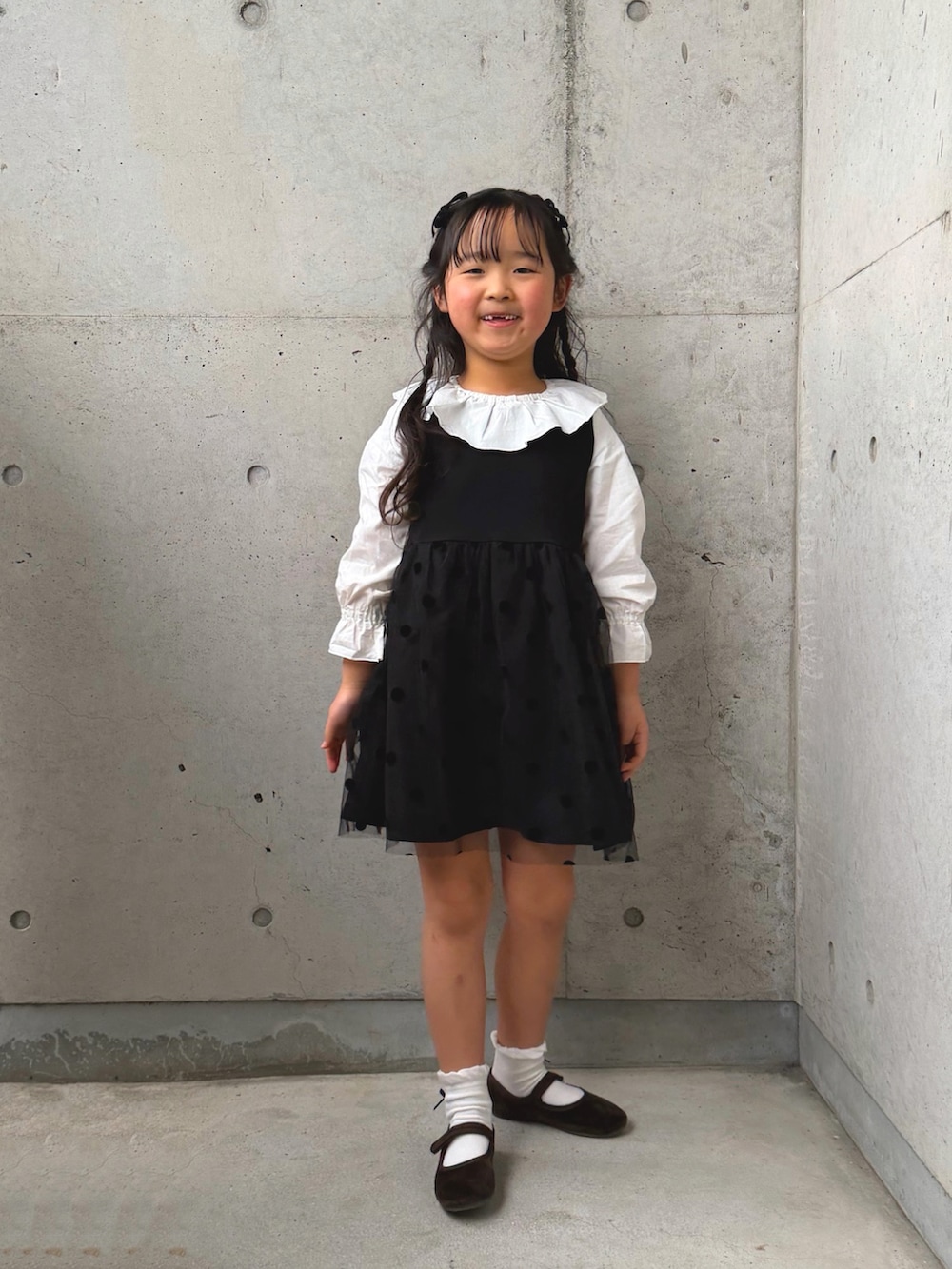 ホワイト系のシャツ/ブラウス、ブラック系のワンピース、ブラウン系のバレエシューズを着用したキッズの冬コーディネートの4枚目の写真